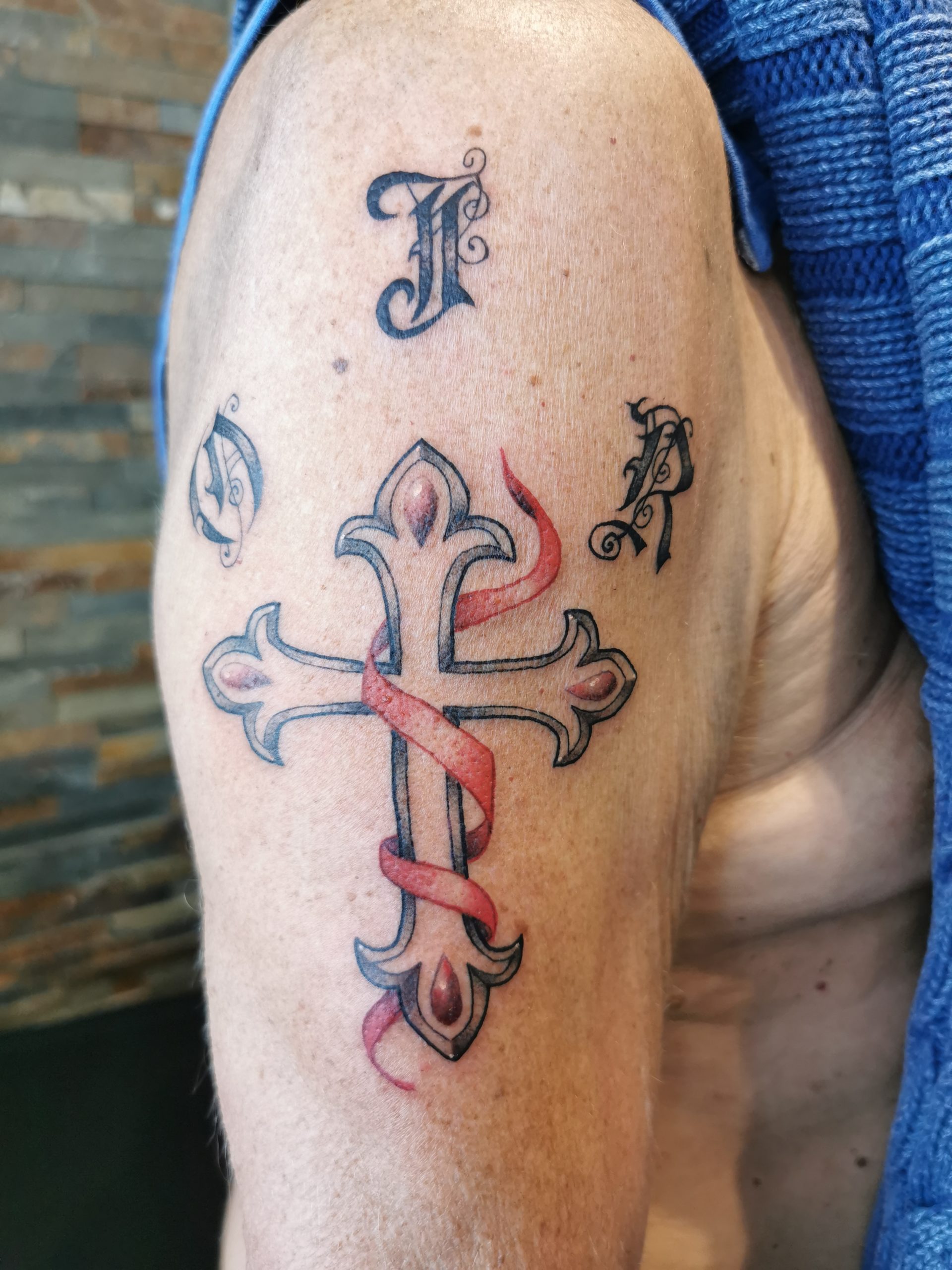 Tatouage croix avec initiales par Saumon-Cru Tarawa Cap d'Agde